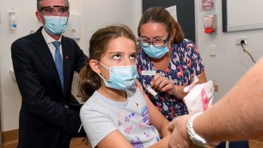 NSW Premier Dominic Perrottet watches as Ines Panagopailos, 8, receives her first dose of the COVID-19 vaccination at the Sydney Children’s Hospital in Randwick on Monday. 
