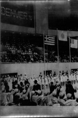 “We meet again in Denver 1976,” reads the sign at the closing ceremony of the 1972 Winter Olympics in Sapporo. The flags of Greece, Japan and the United States fly above the arena.