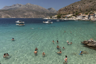Tourists enjoy the sea in Limeni, Greece.