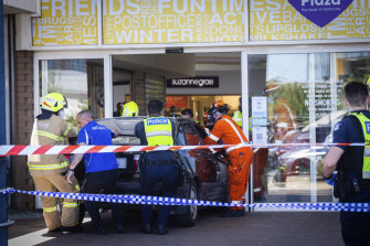 Emergency workers extract the car from the shopping centre.