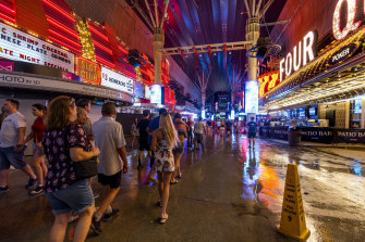 People navigate the rainy walkways as some power is out in Las Vegas.