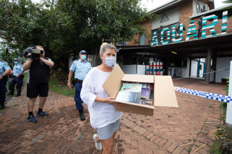 A woman donates books to holidaymakers locked down in the Aquarius Backpackers Lodge in Byron Bay on Thursday.