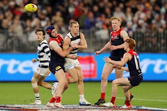 Joel Selwood gets a handball away despite pressure from the Demons.