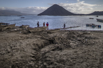 Fishermen stand on a shore covered in volcanic ash from Taal Volcano's eruption on January 20, 2020 in the village of Buso Buso, Laurel, Batangas province, Philippines. 
