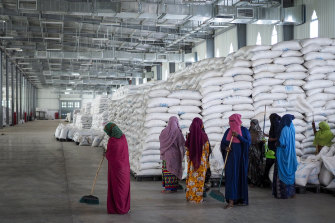 Workers clean the floor as sacks of food earmarked for the Tigray and Afar regions sit in a warehouse of the World Food Program (WFP) in Semera, the regional capital for the Afar region, in Ethiopia, last month.