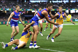 Marcus Bontempelli handballs while being tackled in the Bulldogs’ win over West Coast.