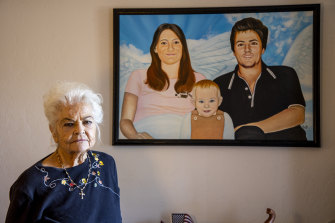 Donna Casasanta poses in front of a painting showing her late son, Harold Dean Clouse, with Clouse’s wife, Tina Gail Linn, and their daughter, Hollie Marie Clouse, at Casasanta’s Edgewater, Fla., home on Friday, January 14, 2022.