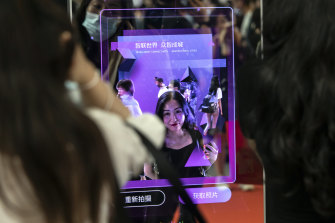 An attendee scans her face at a facial recognition entry gate at the World Artificial Intelligence Conference (WAIC) in Shanghai, China, in July.