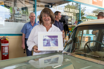 Secretary and board member Ali Pockley holding a photo of the original service station.