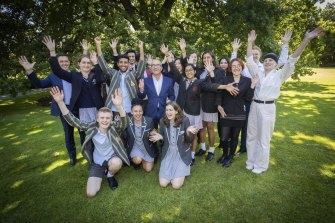 Education Minister James Merlino (centre) and VCAA chief executive Stephen Gniel (far left) celebrate with year 12 graduates on the lawns of Parliament House.