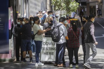 Long lines of people wait to get a COVID-19 test at a Bourke Street clinic.