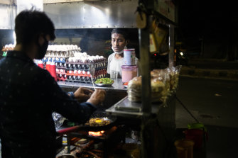 An Indian street food vendor prepares an egg dish for a customer in Ahmedabad.