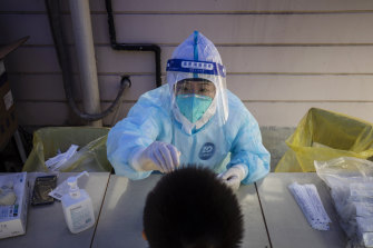週一，在上海的封鎖期間，一名身穿個人防護裝備的工人收集拭子樣本進行一輪 COVID-19 測試。
