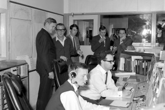 Prime Minister John Gorton (left) visits the Honeysuckle Creek tracking station on the morning of July 21, 1969. 
Seated is John Saxon and Ian Grant. Next to Gorton is station director Tom Reid. 