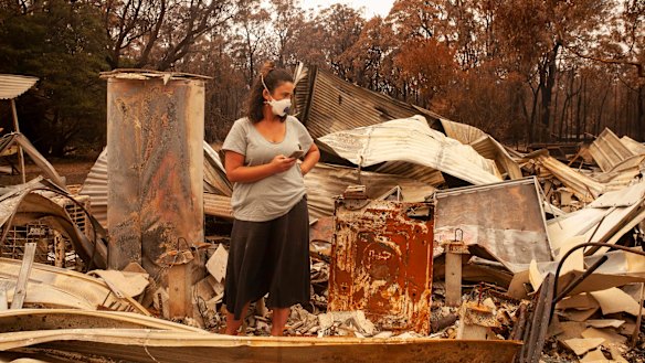 Jessica Van Swol of Mallacoota inspecting the ruins of her home after it was destroyed by the 2019 New Year’s Eve bushfires. 