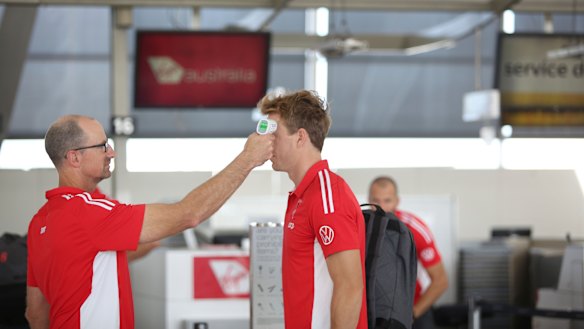 A Swans player having his temperature taken before the team boarded their flight to Adelaide on Friday.
