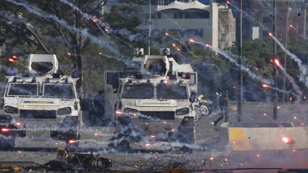 Fire crackers launched by opponents to Venezuela's President Nicolas Maduro land near Bolivarian National Guard armored vehicles during an attempted military uprising in Caracas on Tuesday.