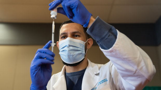 A pharmacy student prepares a dose of vaccine at a mass vaccination super site operated by Sharp HealthCare inside in California.