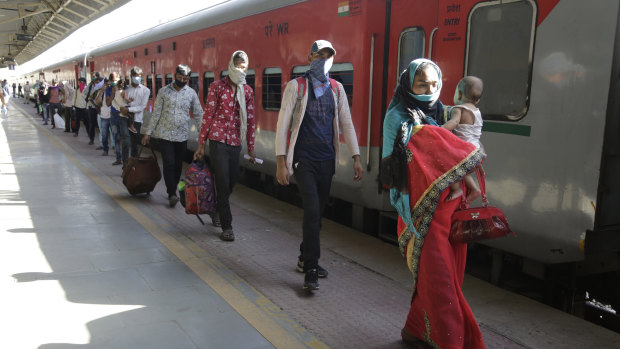 Migrant workers walk to board a special train to return to Agra in Uttar Pradesh state, during a nationwide lockdown.