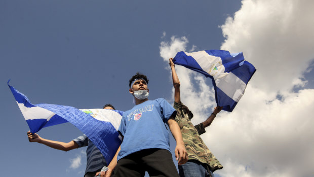 Young men wave national flags during a protest demanding the government release hundreds of protesters held in custody since 2018, in Managua, Nicaragua, on Saturday.