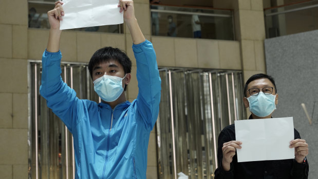 Hong Kong protesters raise white papers at a shopping centre during a pro-democracy protest against Beijing's national security law.