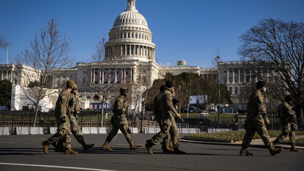 Members of the National Guard walk past a security perimeter outside the US Capitol as preparations are made ahead of the presidential inauguration in Washington.