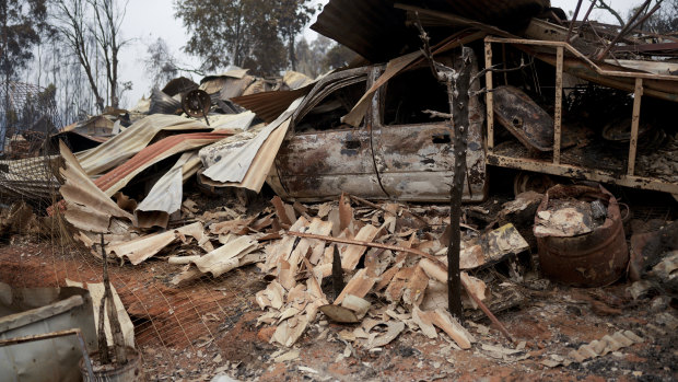 Charred remains of a home burnt in a bushfire sit in a pile in Tome, Chile, on Saturday.
