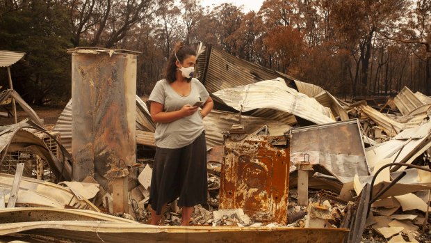 Jessica Van Swol of Mallacoota inspecting the ruins of her home after it was destroyed by the 2019 New Year’s Eve bushfires. 