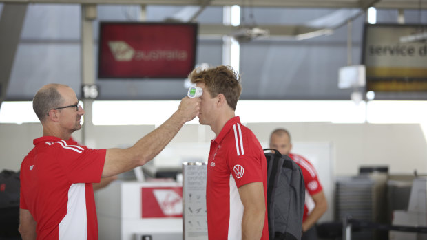 A Swans player having his temperature taken before the team boarded their flight to Adelaide on Friday.
