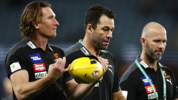 James Hird and Dean Solomon speak with then Giants interim coach Mark McVeigh during the 2022 season.