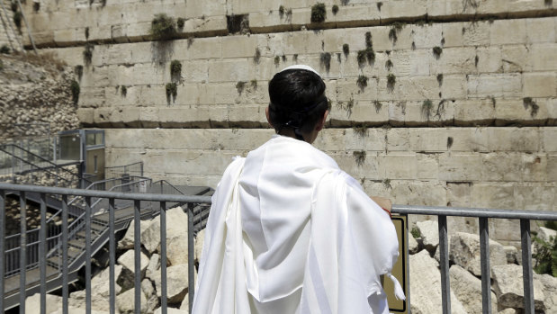 An observer looks at part of the Western Wall where one of the stones dislodged and crashed into the prayer area.