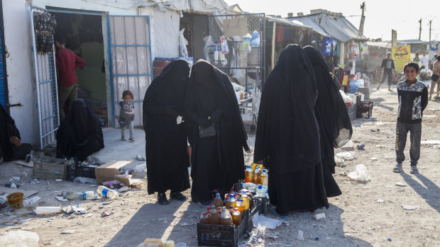 Women buy food at al-Hawl camp, Syria.