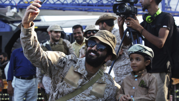 A Saudi soldier takes a selfie with a young boy at the port of Aden in Yemen on Tuesday.