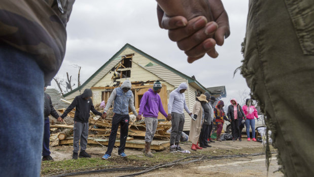 Residents of Talbotton, Georgia, pray together outside a home destroyed by a tornado the day after storms battered Alabama and Georgia.