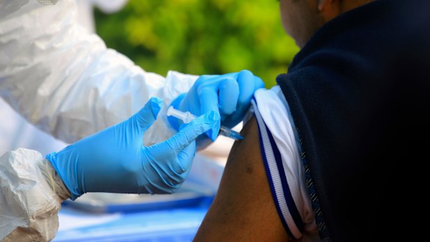 A healthcare worker from the World Health Organisation gives an Ebola vaccination to a front line aid worker in Mangina, Democratic Republic of Congo.