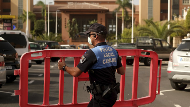 A police officer sets a barrier blocking the access to the H10 Costa Adeje Palace hotel in Tenerife.