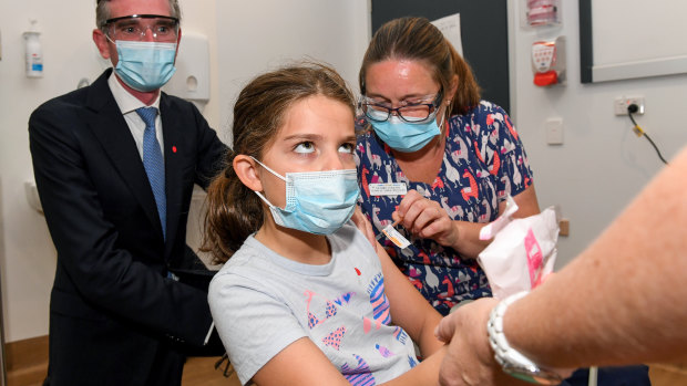 NSW Premier Dominic Perrottet watches as Ines Panagopailos, 8, receives her first dose of the COVID-19 vaccination at the Sydney Children’s Hospital in Randwick on Monday. 