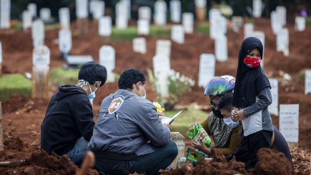 Relatives visit the grave of a COVID-19 victim.