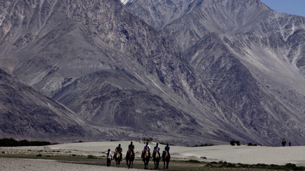Tourists ride double hump camels at Nubra valley, in Ladakh, India - the scene of a stand-off between nuclear powers India and China.