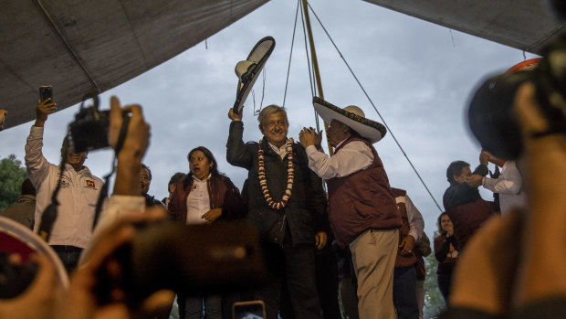 Andrés Manuel López Obrador, a presidential candidate commonly known as AMLO, greets the crowd during a campaign rally in Chimalhuacán, on the outskirts of Mexico City.