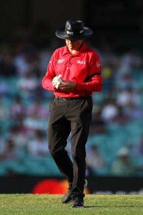 Australian umpire Sam Nogajski cleans the ball after it was returned from the crowd from a six during game one of the One Day International series between Australia and India at Sydney Cricket Ground.
