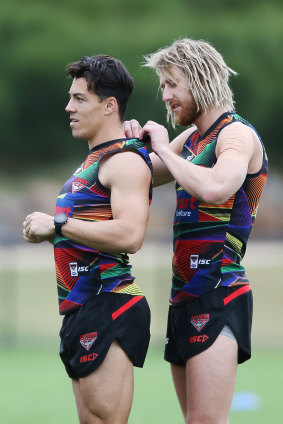 Dyson Heppell of the Bombers inserts a GPS device on Dylan Shiel.