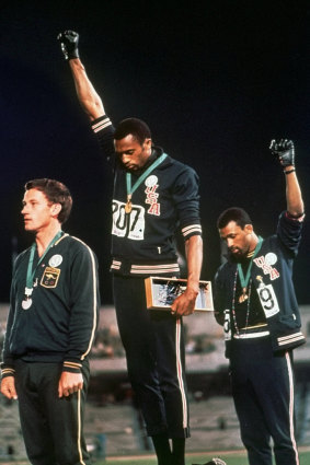 US athletes Tommie Smith and John Carlos, with Australia's Peter Norman, in their famous pose at the 1968 Games in Mexico. 