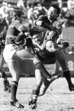 Hugh McGahan in action for Easts at Brookvale Oval in 1986.  He is tackled by Des Hasler (left) and Cliff Lyons. 