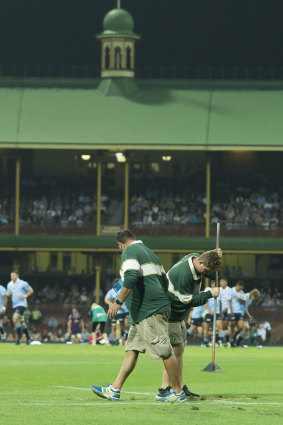 Running repairs: Ground staff get busy during a break in play in the Waratahs-Reds match.