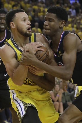 LA Clippers guard Shai Gilgeous-Alexander, vies with Stephen Curry.