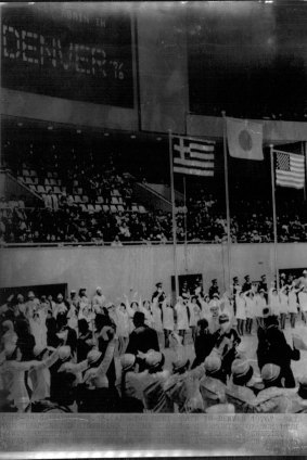 “We meet again in Denver 1976,” reads the sign at the closing ceremony of the 1972 Winter Olympics in Sapporo. The flags of Greece, Japan and the United States fly above the arena.