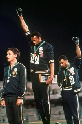American athletes Tommie Smith, centre, and John Carlos extended gloved hands in a protest at the Mexico City Games in 1968. Silver medallist Australia’s Peter Norman stands on the left. He wore a badge supporting the “Olympic Project for Human Rights”.