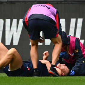 Steven May is attended to by trainers during Melbourne’s round four clash with Geelong at the MCG.