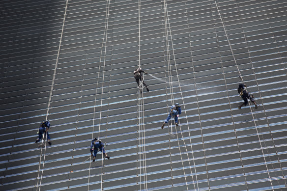 Workers clean the exterior of an office building in Singapore. The island-nation is well-known for its strict regulations regarding cleanliness and crime.